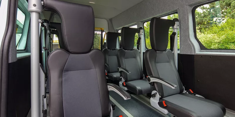 Bild von einem Kleinbus auf einer Straße, umgeben von Bäumen